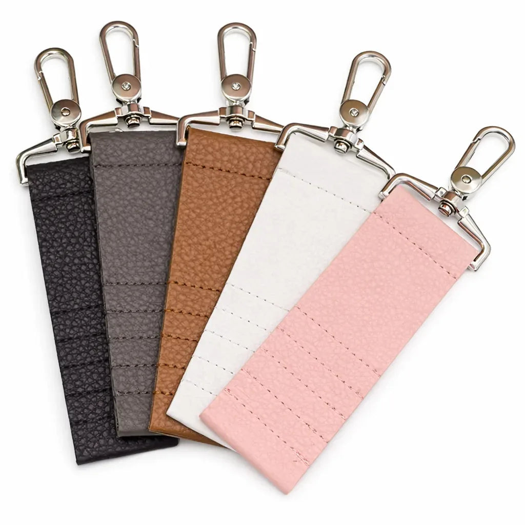 5 colors of Leather Golf Tee Holder Keychains on white table.