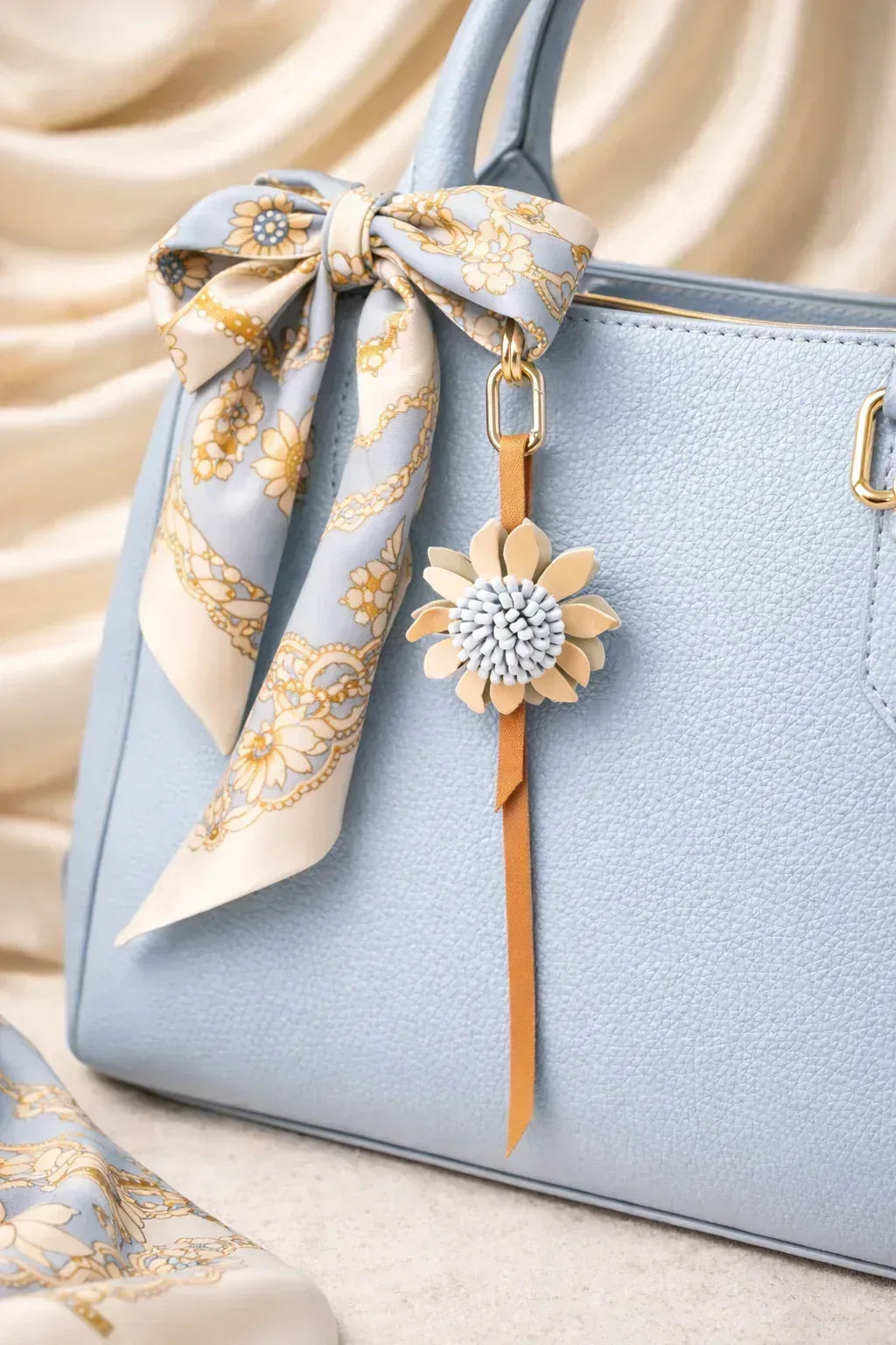 Light blue Autumn Rosette Charm on blue purse with scarf. 
