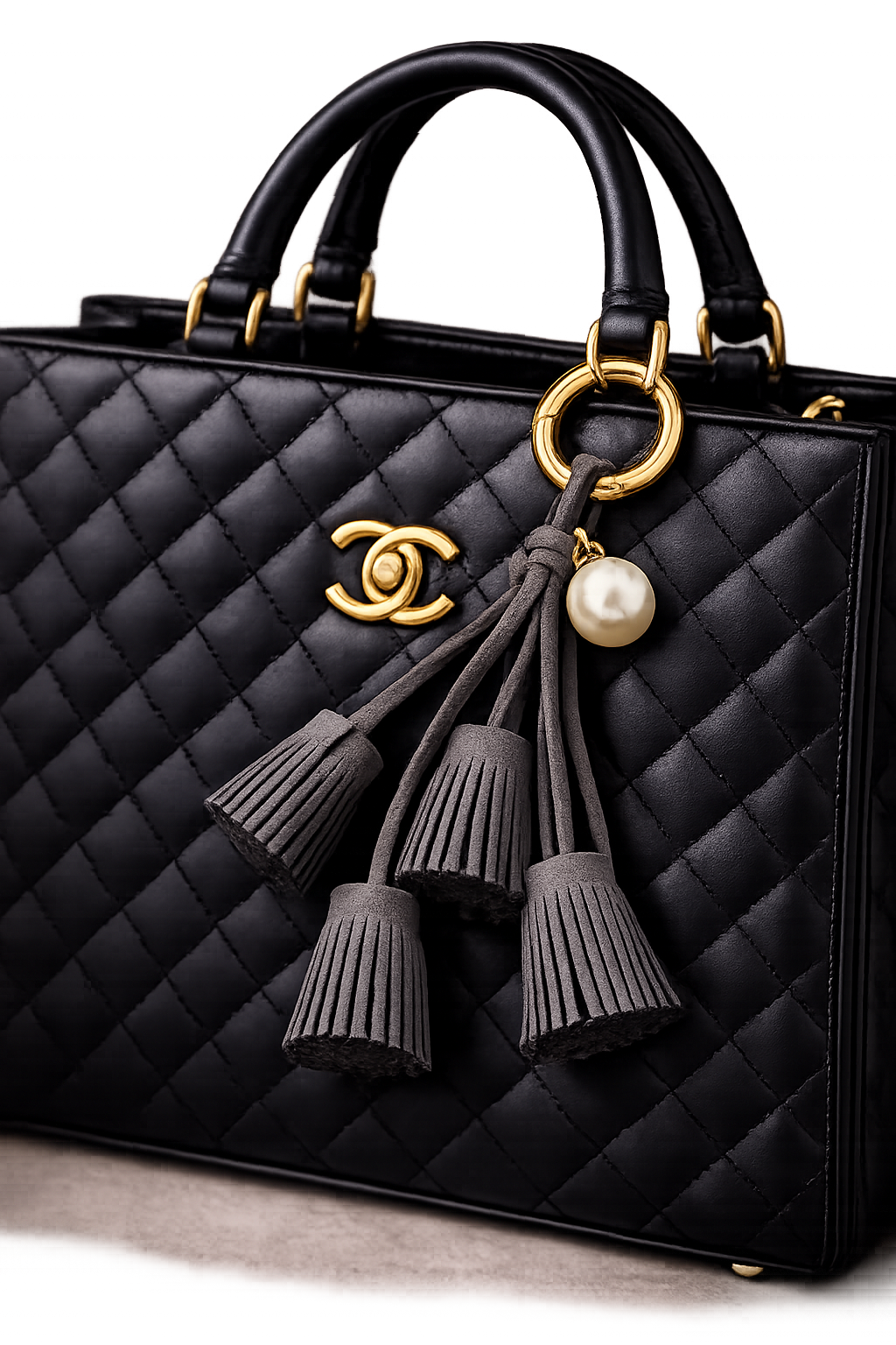 Black Suede & Pearl Tassel Bag Charm with pearl accent on brass key ring on black luxury bag. 