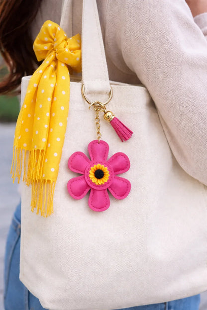 Pink leather flower bag charm styled on a white summer tote bag.