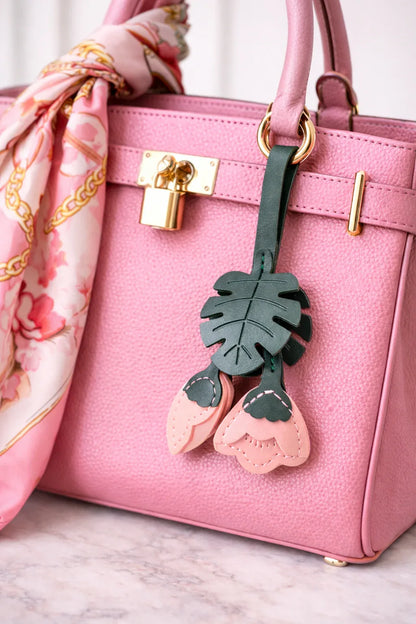Pink Monstera Bloom Leather Bag Charm with leather strap on a pink luxury bag with scarf. 