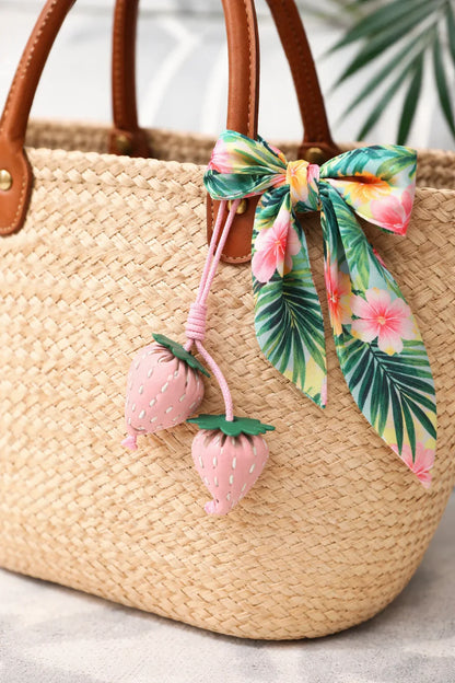 Pink Fraise Duet Strawberry Bag Charm Set with leather cord strap on straw bag with scarf. 