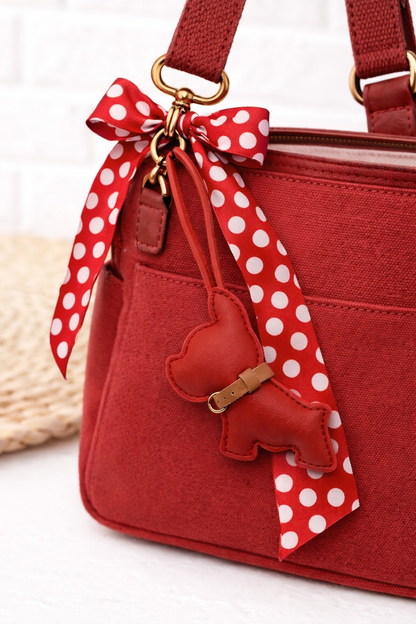 Red Pocket Puppy Leather Bag Charm  with collar on a red purse with scarf. 