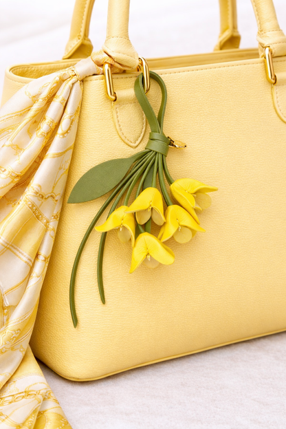 Yellow  Petite Lily Bag Charm with leather strap on Yellow purse with scarf. 