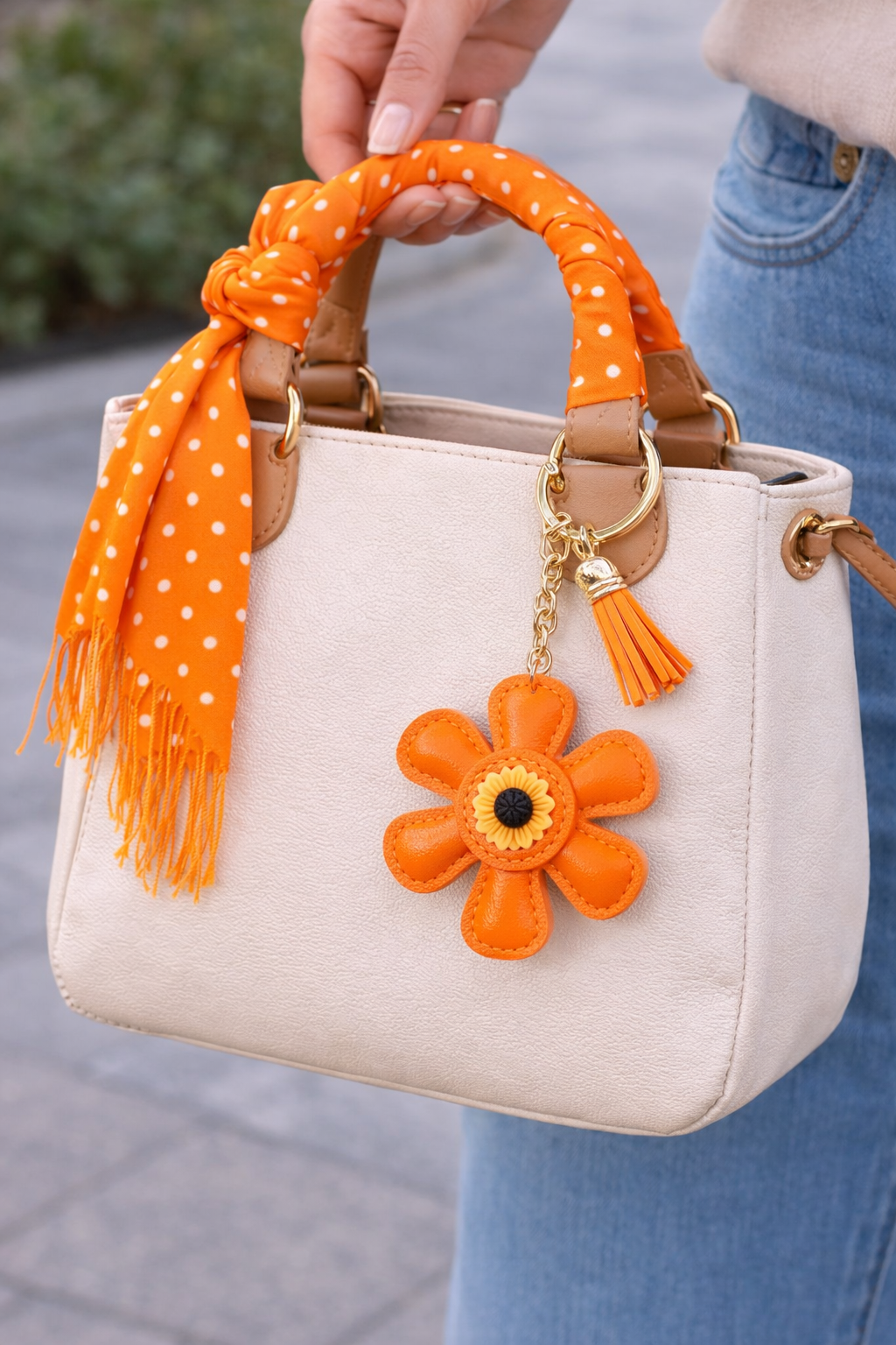 Orange leather flower bag charm styled on a white summer tote bag.