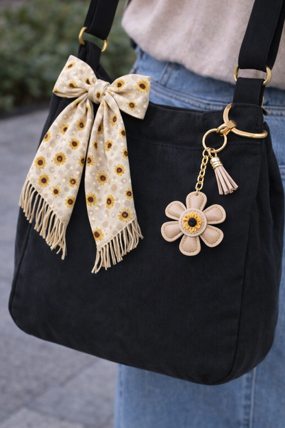 Tan  leather flower bag charm styled on a Black summer tote bag.