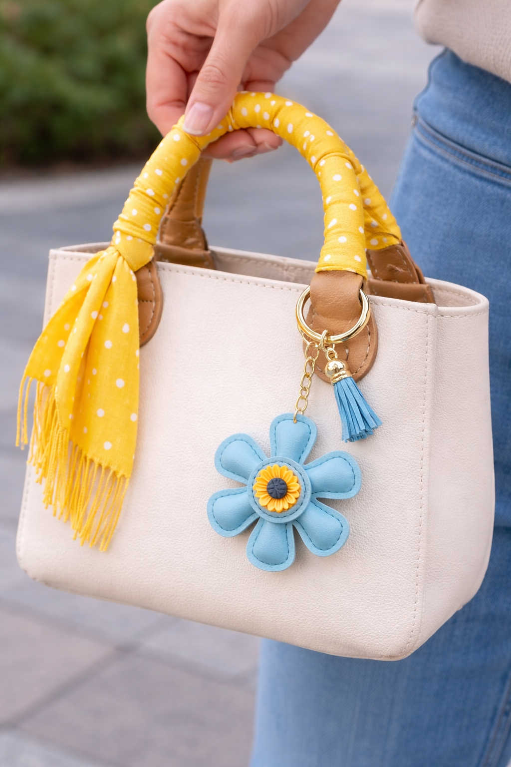 Teal leather flower bag charm styled on a white summer tote bag.