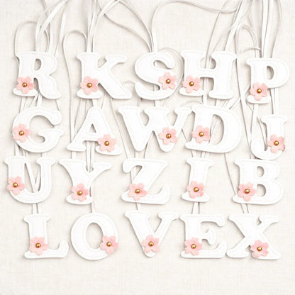 Various Initials in Bloom Alphabet Bag Charms  with leather strap on white background. 