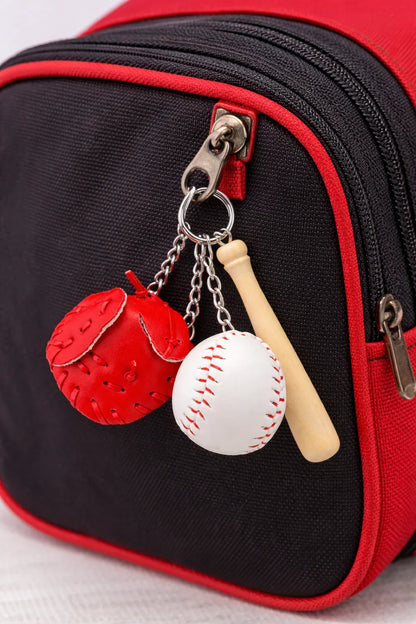 Baseball, glove and bat keychain on a black and red backpack. 