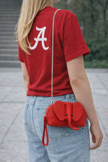 Small genuine leather elephant purse worn as a crossbody mini bag to show size and fit.