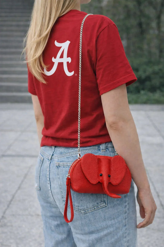 Small genuine leather elephant purse worn as a crossbody mini bag to show size and fit.