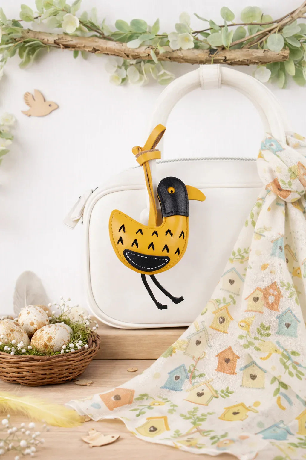 Golden Yellow Feathered Friend Leather Bag Charm  on white purse.