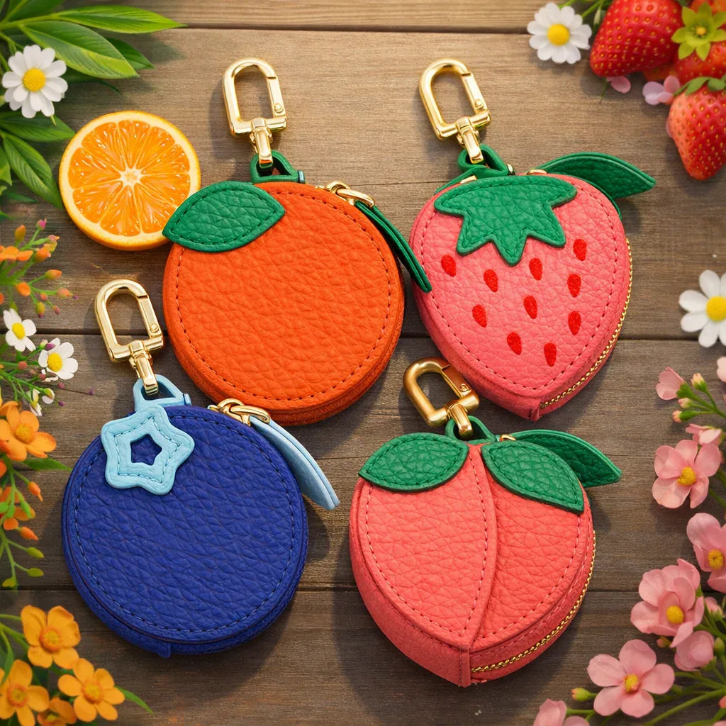 Collection of 4 fruit-shaped mini coin pouches including strawberry, peach, orange, and blueberry.