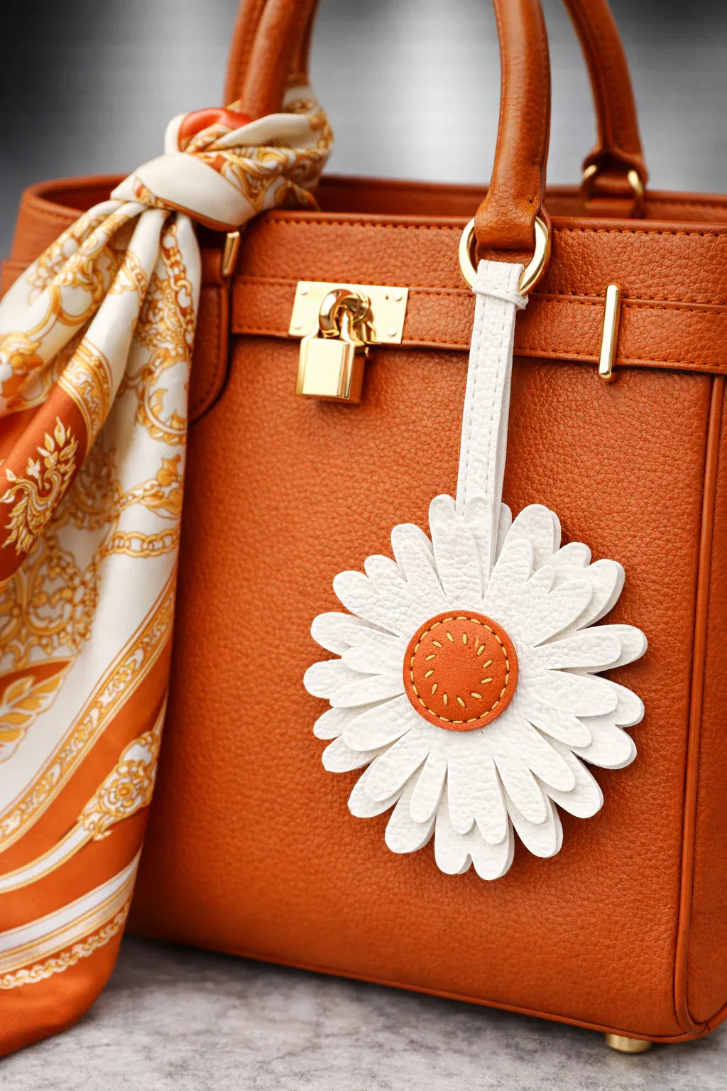 Sunlit Daisy Leather Bag Charm  with leather strap on orange purse with scarf to show style. 