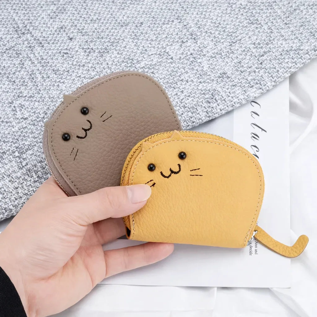 Small cat-shaped coin purse held in hand to show the compact size of the cardholder.