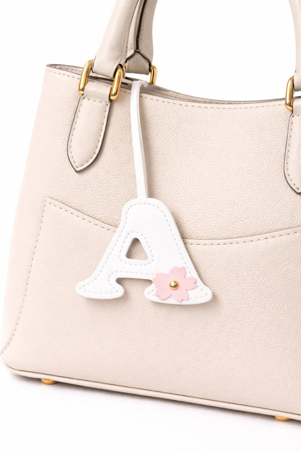 Initials in Bloom Alphabet Bag Charm "A" with leather strap on white purse.