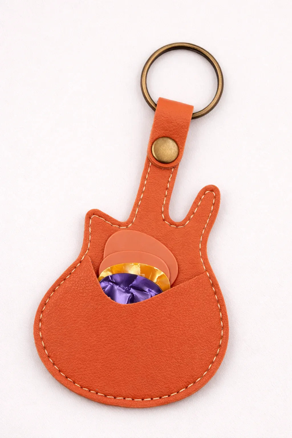 Handmade orange guitar-shaped leather keychain with a secure pick pocket and brass-tone ring.