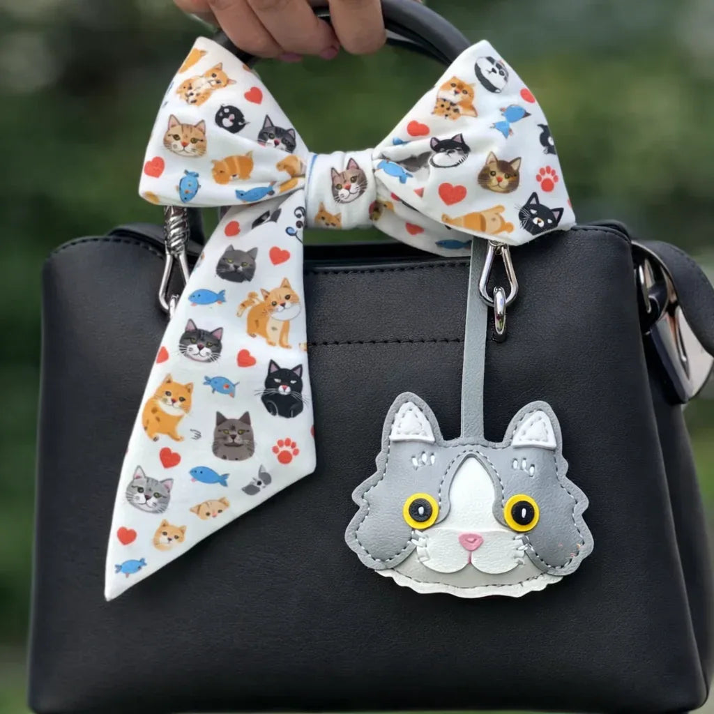Grey Whiskered Heirloom Leather Cat Charm on black purse with scarf.