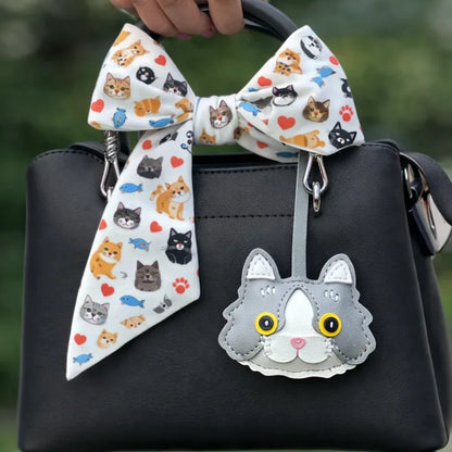 Grey Whiskered Heirloom Leather Cat Charm on black purse with scarf.