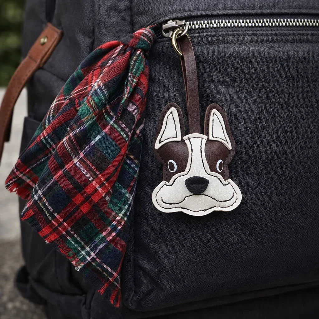 Black Bulldog Leather Bag Charm with leather strap on black backpack zipper.