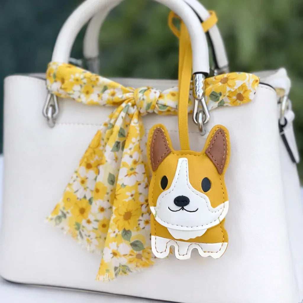 Yellow Corgi Companions Leather Bag Charm with leather strap on white purse and scarf. 