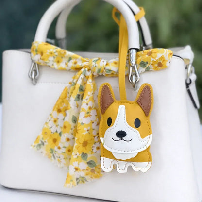 Yellow Corgi Companions Leather Bag Charm with leather strap on white purse and scarf. 