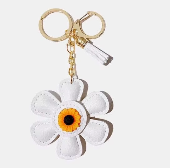 Handmade white leather daisy keychain with yellow center and gold clasp.