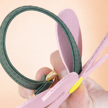 Close up of a Petal Pop Bag charm to show size and detail and leather strap and brass ring. 