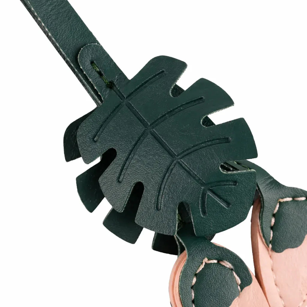 Close up of the Pink Monstera Bloom Leather Bag Charm. 