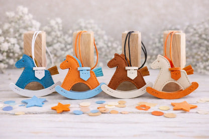 4 various colored Rockabye Keepsake Horse Charms  on wood blocks with flowered background .