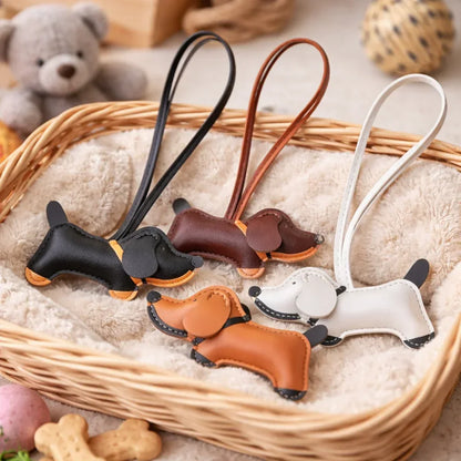 4 different colored Chic Leather Dachshund Bag Charms with leather straps on blanket in straw basket. 