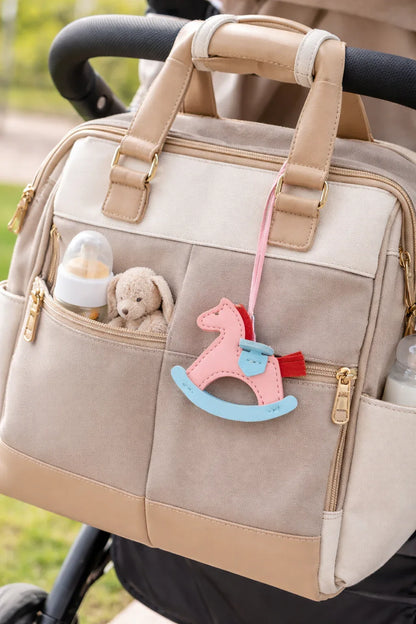 Cream Rockabye Keepsake Horse Charm on diaper bag on stroller. 