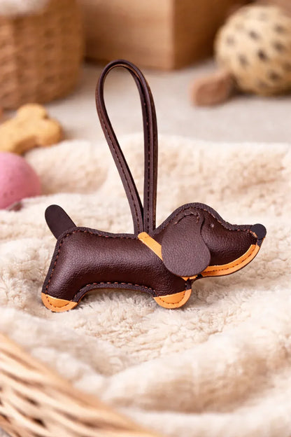 Chic Brown Leather Dachshund Bag Charm  with leather strap sitting on blanket. 