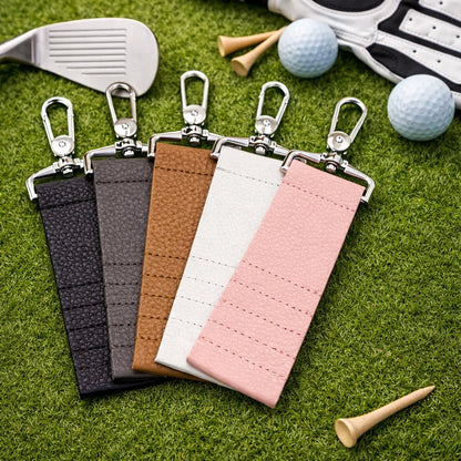 5 colors of Leather Golf Tee Holder Keychain on grass and with golf accessories.