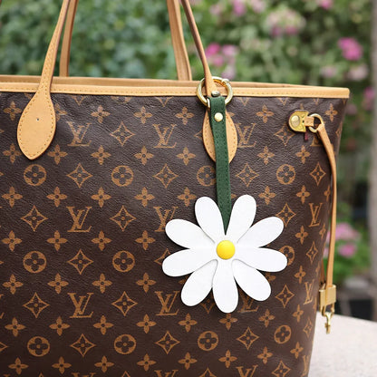 White Petal Pop Bag Charm on a luxury bag to show style. 