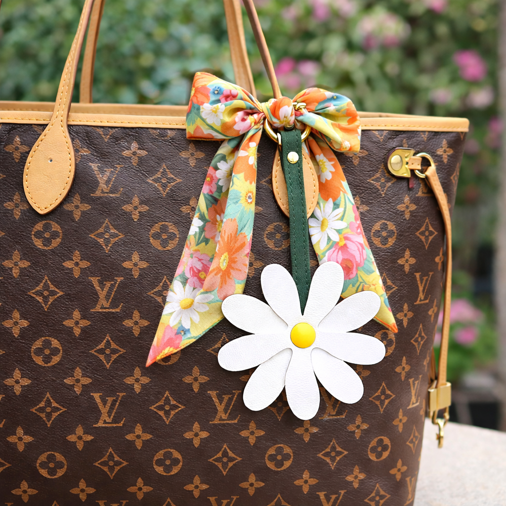 White Petal Pop Bag Charm on a luxury bag with scarf to show style. 