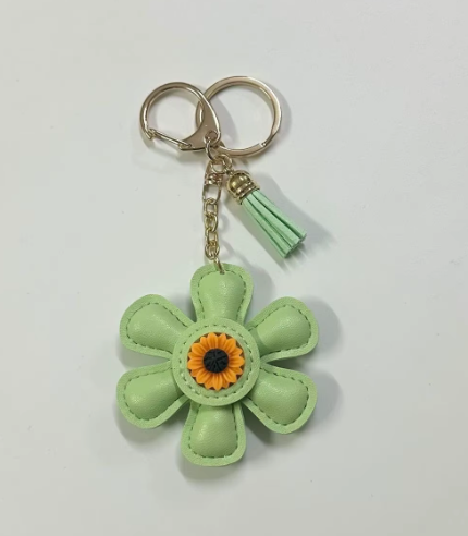 Handmade green leather daisy keychain with yellow center and gold clasp.