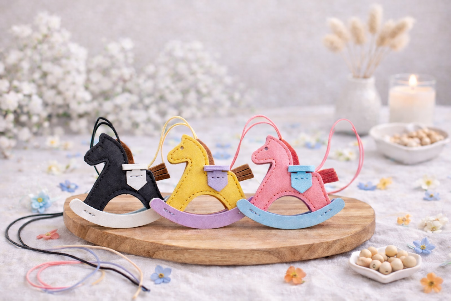 3 various colored Rockabye Keepsake Horse Charms  on wood blocks with flowered background .