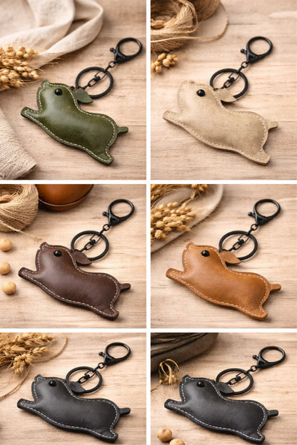 6 Leather Pig Key Chain and Bag Charm with Key ring and clasp on table.