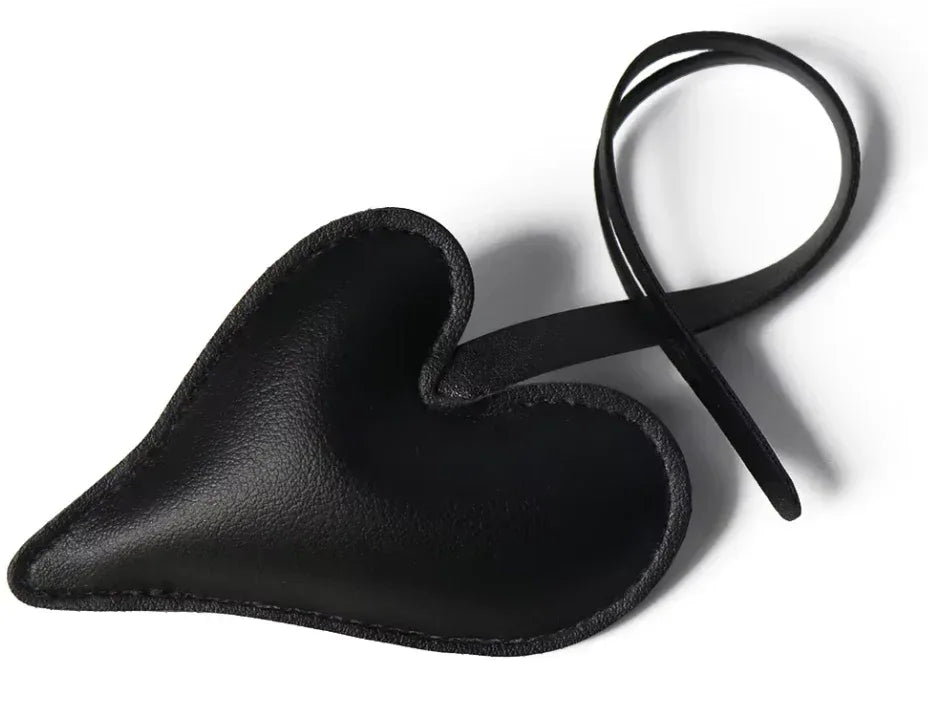 Black Carry Your Heart Collection Leather Heart Bag Charm on white background. 