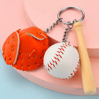 Baseball, glove and bat keychain on a Tan table. 