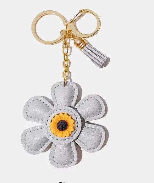 Handmade pink leather daisy keychain with yellow center and gold clasp.