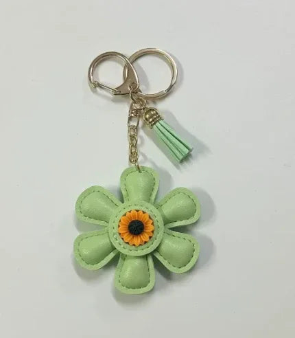 Handmade green leather daisy keychain with yellow center and gold clasp.