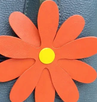 Close up of a coral Petal Pop Bag charm to show size and detail. 