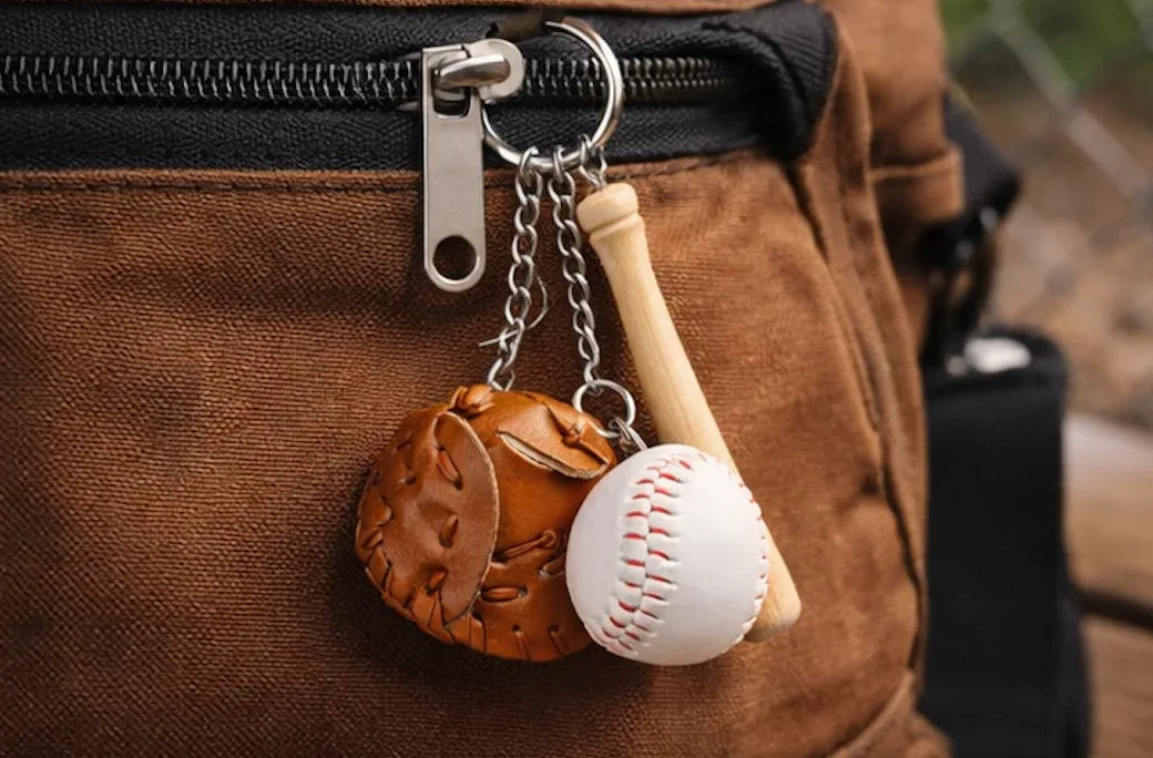 Baseball, glove and bat keychain on a pant zipper. 