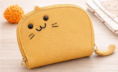 Handcrafted yellow cat-shaped leather cardholder with a cute whiskered face and secure gold zipper and tail. 