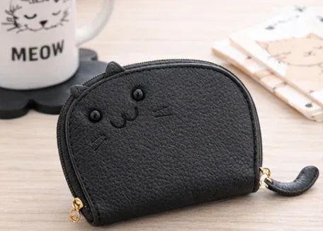 Handcrafted black cat-shaped leather cardholder with a cute whiskered face and secure gold zipper and tail. 