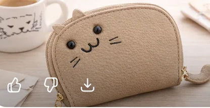 Handcrafted tan cat-shaped leather cardholder with a cute whiskered face and secure gold zipper and tail. 