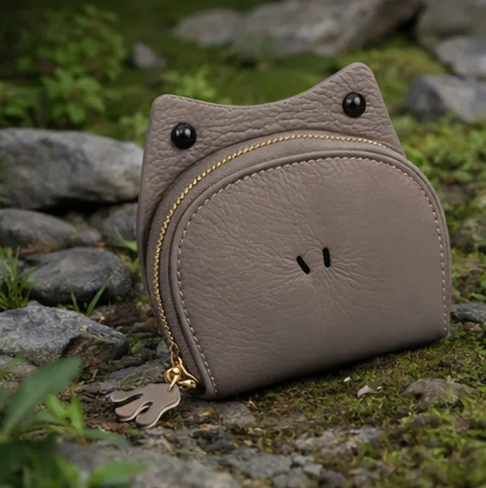 Handcrafted green leather frog-shaped card holder with a smiling face and gold zipper.