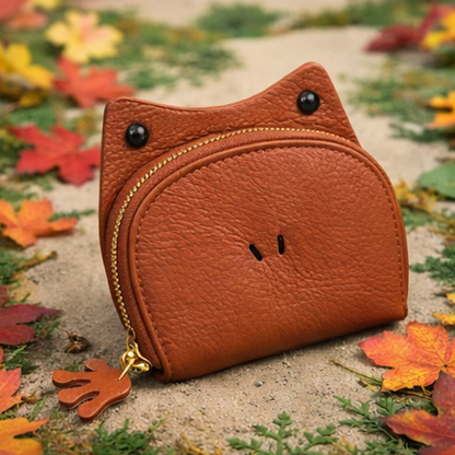 Handcrafted brown  leather frog-shaped card holder with a smiling face and gold zipper.